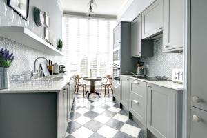切尔滕纳姆16 Lansdown Flat 3 - By Luxury Apartments的厨房配有白色橱柜和 ⁇ 格地板