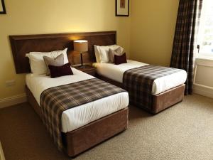 巴洛赫Cameron Club Lodges的酒店客房设有两张床和窗户。