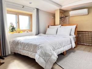 济州市Jeju Time的一间卧室设有一张床和一个窗口