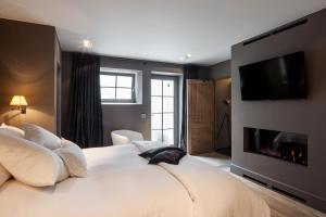 LievegemB&B De Lievde的卧室配有一张大白色床和平面电视