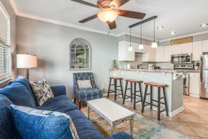 奥兰治比奇Summer Breeze 21的一间带蓝色沙发的客厅和一间厨房