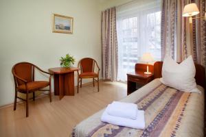 斯克拉斯卡波伦巴Mauritius Ośrodek Szkolenia Sportu i Rekreacji的一间卧室配有一张床、一张书桌和一个窗户。