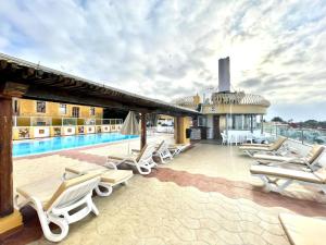 拉克鲁斯萨莎德索尔酒店的一组躺椅和一个游泳池,位于一栋大楼内