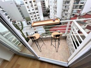 布宜诺斯艾利斯Petite Maison II的阳台配有两把椅子和一张桌子