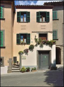 巴尼奥雷焦拉洛盖塔住宿加早餐旅馆的一座带绿色百叶窗的建筑和一个车库