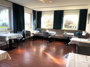 瓦瑟堡盖茨豪斯祖兰酒店的餐厅设有白色的桌椅和窗户。