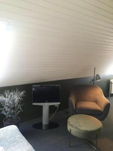 RoslevRoslev Hus的客房设有电视、椅子和书桌。