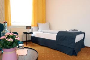皮尔纳Hotel Sächsischer Hof的配有床和鲜花桌的酒店客房