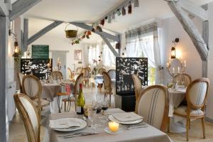 Soings-en-SologneLogis Hôtel Restaurant LE VIEUX FUSIL的一间设有白色桌椅的餐厅和一间房间
