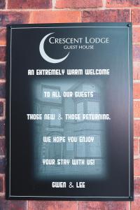 惠特比Crescent Lodge Guest House的砖墙上的一个宾馆标志