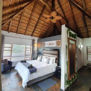 马布拉636 Itaga Safari Lodge, Mabalingwe Nature Reserve的一间卧室设有一张大床和木制天花板
