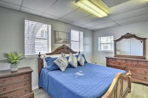 代托纳海滩Serene Daytona Beach House with Private Yard!的一间卧室配有一张蓝色的床、梳妆台和镜子