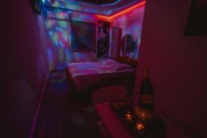 梅阿利亚达Motel Príncipe Encantado的一间设有两张床的房间,房间拥有红色和蓝色的灯光