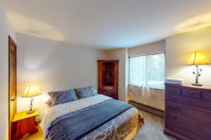 西优胜美地Forest Glen的一间卧室配有一张床、一个梳妆台和一扇窗户。
