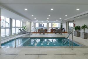 格拉玛多Laghetto Stilo Vita的一座带用餐区的建筑中的室内游泳池