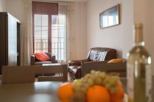 克雷克塞利Apt Costa Dorada 1 by MarCalma的客厅配有两把椅子和一张橙色桌子