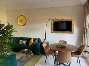 马拉喀什Appartment Rhizlane的客厅配有绿色沙发和桌子