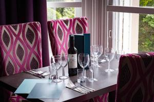 梅尔罗斯韦弗利城堡酒店的一张桌子,上面有眼镜和一瓶葡萄酒