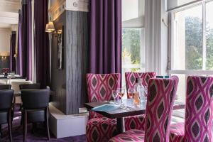 梅尔罗斯韦弗利城堡酒店的餐厅设有粉红色的椅子和一张带酒杯的桌子