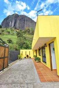 瓜塔佩Hermosa casa de campo en GUATAPÉ的一座黄色房子,后面有山