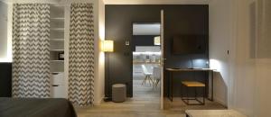 马里博尔Apartments CityMap Maribor-Free parking!的客房设有一张床、一张书桌和一间厨房
