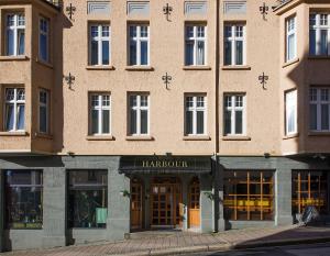 卑尔根Bergen Harbour Hotel, WorldHotels Crafted的一座大型砖砌建筑,设有harcourt商店