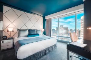 温哥华Paradox Hotel Vancouver的一间卧室设有一张大床和一个大窗户
