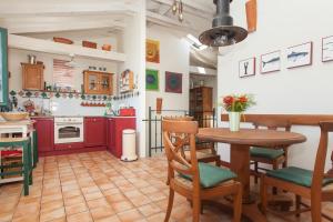 罗维尼卡萨苏尔玛尔旅馆的厨房配有红色橱柜和桌椅