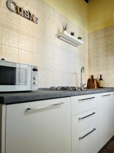 锡耶纳La Casina Verde的厨房配有白色橱柜和微波炉