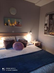 Saint-Seurin-de-CursacL'Estuaire的一间卧室配有一张带紫色枕头的床