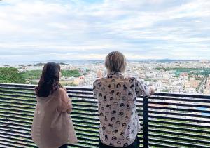 浦添D-and Stay 5 Resort Okinawa的两个人站在一个市景阳台