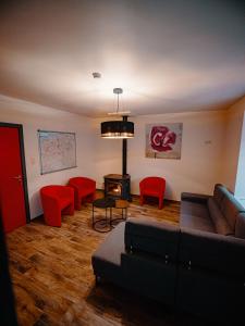 La Roche MadouxLa porte du paradis的带沙发和红色椅子的客厅