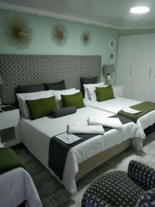 帕罗Mitchell's Guesthouse的一间卧室配有两张大床和绿色枕头