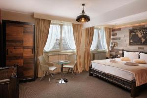 雅西Piata Unirii Central Apartments的卧室配有一张床和一张桌子及椅子
