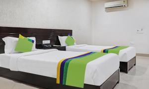 兰奇Treebo Trend Elite City Upper Bazar的两张位于酒店客房内的单人床,配有四柱床