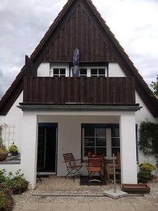 卡珀尔恩Ferienwohnung Hansen in Hafennähe的白色的小房子,设有木屋顶和桌子