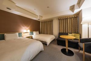 宇都宫宇都宫东武格兰德酒店的酒店客房设有两张床、一张沙发和一张桌子。