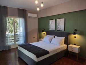 卡诺尼Beautifull And Airy Appartment Corfu Town的一间卧室设有一张大床和绿色的墙壁