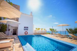 比利亚霍约萨赛维格里普蒙蒂博里酒店的一个带椅子和遮阳伞的游泳池以及大海