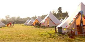 瓦伊河畔海伊Glamping at Hay Festival的田野里一排帐篷,人们四处走动