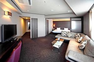 堺市萨凯太阳广场酒店的酒店客房设有沙发、电视和床。