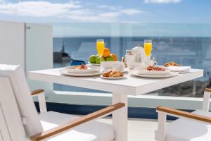 卡列罗港Royal Marina Suites Boutique Hotel的餐桌,带食物和橙汁盘