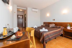 安道尔Hotel Sierra de Arcos的一间卧室配有一张床和一张桌子,并提供一个食品托盘