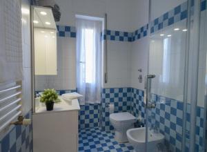 米兰Milanoverse Apartment的蓝色和白色的浴室设有卫生间和淋浴。