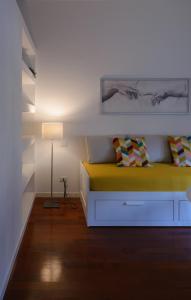 米兰Milanoverse Apartment的一间卧室配有黄色的床和一盏灯