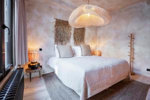 安特卫普BTFL Living Antwerp的卧室配有白色的床和吊灯。