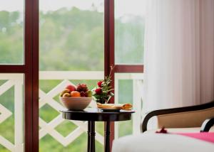 大叻瑞士伯莱索特宣林度假村的窗户前的桌子上放着一碗水果