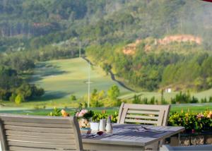 大叻瑞士伯莱索特宣林度假村的一张桌子和两把椅子,享有山景