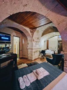 乌奇希萨尔Mimi Cappadocia Luxury Cave Hotel的一间卧室配有带毛巾的床