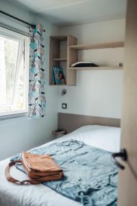 AubazinesMobil Home XXL 4 chambres - Camping Le Coiroux的一间卧室设有一张床和一个窗口
